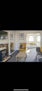 a living room with two couches and a fireplace at Village view apartments in Tynemouth