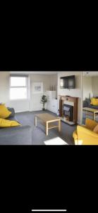 a living room with a couch and a table at Village view apartments in Tynemouth