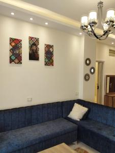 a blue couch in a living room with paintings on the wall at Hurghada's Marina view in Hurghada