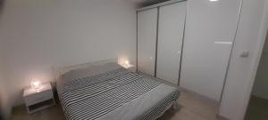 ein Schlafzimmer mit einem Bett mit zwei Leuchten in der Unterkunft Apartman XXL in Brčko