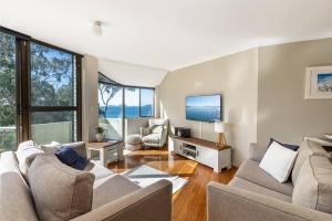 uma sala de estar com dois sofás e uma televisão em Tranquil Escape - Koala Hotspot - 2 Bed 2 Bath Apt Spectacular Sea Views em Soldiers Point