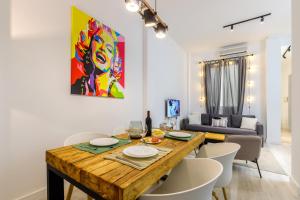 comedor y sala de estar con mesa de madera y sillas en Apartamentos Tribuna, en Málaga