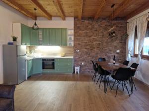 a kitchen with green cabinets and a table with chairs at Ruralna kuća za odmor - Bitunjac in Levanjska Varoš +18 photos