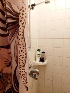 y baño con ducha con cortina de ducha de estampado de leopardo. en Residenssi Tuuli, en Varkaus