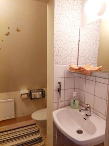 a bathroom with a sink and a toilet at Residenssi Tuuli in Varkaus
