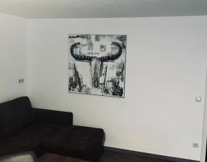 a living room with a couch and a picture on the wall at Ferienwohnung an der Allee in Memmingen in Memmingen