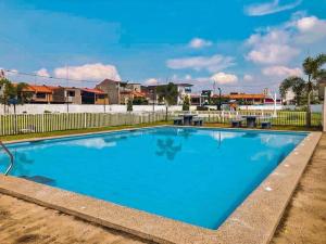 a large blue swimming pool with a fence at Happy Dwellers in Marilao