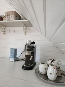 uma cafeteira e panelas de chá num balcão em Pirts māja em Engure