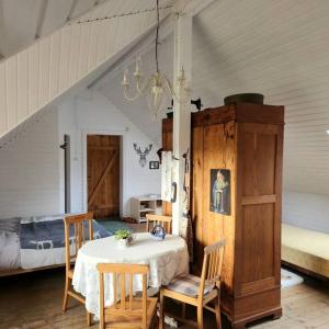 a dining room with a table and chairs and a bed at Pirts māja in Engure