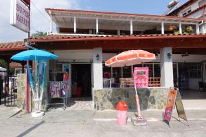 a store with an umbrella and a sign in front of it at Camping Mitikas and Bungalows in Plaka Litochorou