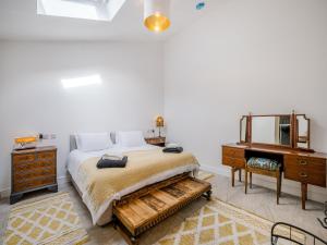 Schlafzimmer mit einem Bett, einer Kommode und einem Spiegel in der Unterkunft Angeliki - Uk43588 in Ellesmere