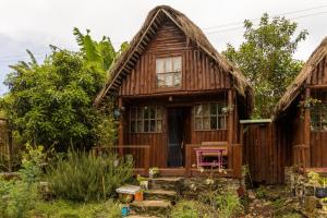 ein Holzhaus mit einem Strohdach in der Unterkunft Kalitusi Nature Resort in Fort Portal