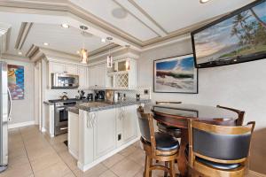 a kitchen with white cabinets and a table and chairs at Villa Leone at the Retreat in Laguna Beach in Laguna Beach