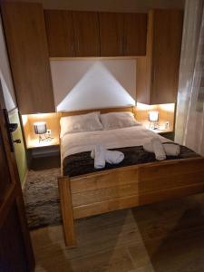 a bedroom with a large bed with two lamps on it at Ruralna kuća za odmor - Bitunjac in Levanjska Varoš