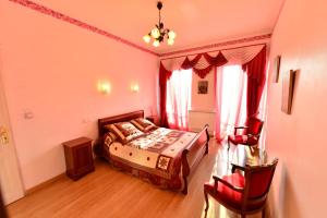 a bedroom with a bed and a table and chairs at Au Pied du Chateau in Lourdes