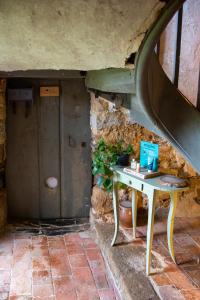Una pequeña mesa en una habitación con una pared de piedra en Valtro le Nid - logement entier proche 24 heures du Mans et Grottes de Saulges, en Saulges