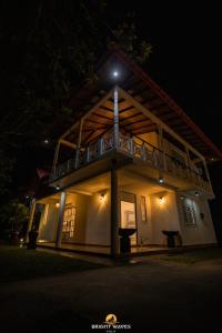 a house with a balcony at night at Bright Waves Villa in Bentota