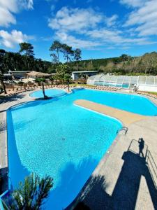 una gran piscina de agua azul en Mobilhome climatisé 6 psn, en Lège-Cap-Ferret