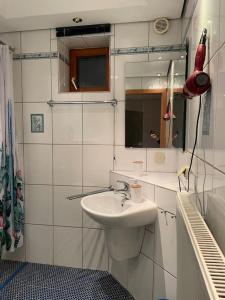 a white bathroom with a sink and a mirror at Apartment mit Ausblick in Lambrecht