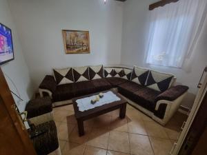 ein Wohnzimmer mit einem Sofa und einem Couchtisch in der Unterkunft Romeo's Guest House in Berat