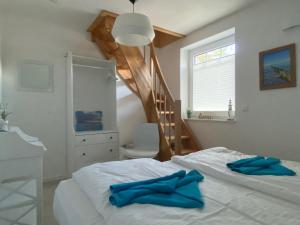 a bedroom with a bed with blue towels on it at Min Droom Usedom in Zirchow