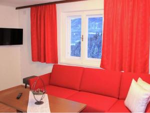 sala de estar con sofá rojo y ventana en Neuhäusl in Brandenberg with a sauna and a wonderful view, en Brandenberg