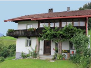 een wit huis met een balkon op een heuvel bij Chalet in Tyrol with Sauna and Ski Slopes in Brandenberg