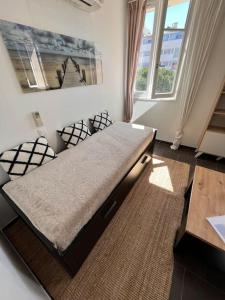 een groot bed in een kamer met 2 ramen bij Studio centre historique vue Mer in Sainte-Maxime