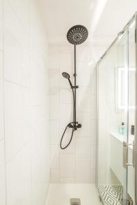 a white bathroom with a shower with a glass door at @ I LOVE BG @ proche gare et centre historique in Brive-la-Gaillarde