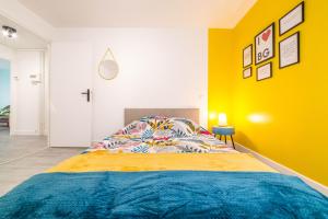 a bedroom with a bed with a yellow wall at @ I LOVE BG @ proche gare et centre historique in Brive-la-Gaillarde