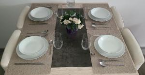 een tafel met witte borden en zilverwerk erop bij Appartement T2 confortable in Pierrelaye