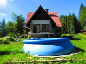 um par de barcos azuis sentados em frente a uma casa em Sanjska Hiša Vojsko em Idrija