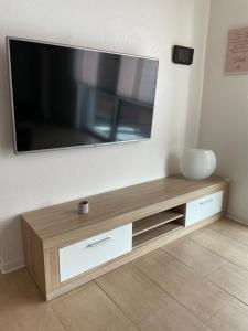 TV de pantalla plana en la pared en MR Ferienwohnung - Wohnung Borsum, 