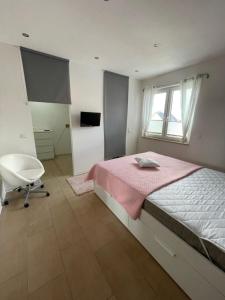 sypialnia z łóżkiem, krzesłem i oknem w obiekcie MR Ferienwohnung - Wohnung Borsum 
