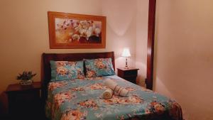 ein Schlafzimmer mit einem Bett mit einer bunten Bettdecke und Kissen in der Unterkunft Pousada Recanto Lisieux in Marechal Floriano