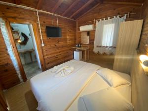 a bedroom with a bed with a towel on it at Kidrak Hotel in Faralya