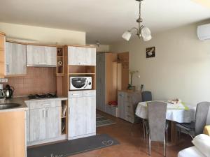 a small kitchen with a table and a dining room at Jázmin Deluxe Apartman in Harkány