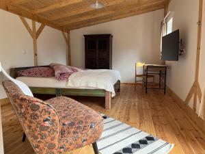 ein Schlafzimmer mit einem Bett, einem Stuhl und einem Tisch in der Unterkunft Stadthaus Usedom in Usedom Town