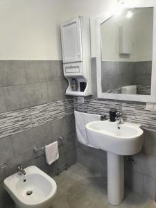 ein Badezimmer mit einem Waschbecken, einem Spiegel und einem WC in der Unterkunft Casa di Aurora in Guidonia