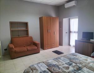 ein Schlafzimmer mit einem Bett, einem Stuhl und einem Schrank in der Unterkunft Casa di Aurora in Guidonia