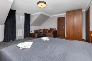 a bedroom with a bed with two towels on it at GARDEN Restaurant & Pension in Pardubice