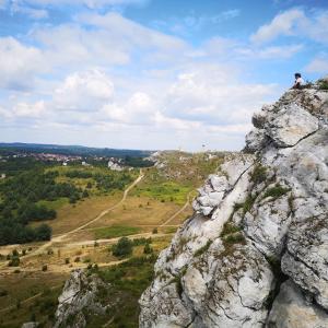 una persona sentada en la cima de una montaña rocosa en Pod LIPÓWKAMI, en Olsztyn