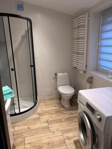 een badkamer met een toilet en een wasmachine bij Pod LIPÓWKAMI in Olsztyn
