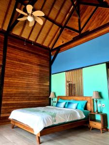Beach House Penida في نوسا بينيدا: غرفة نوم بسرير ومروحة سقف