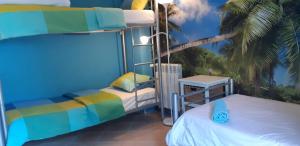 a bedroom with two bunk beds and a palm tree at Amazigh Guincho Hostel & Suítes in Cascais