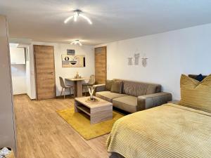 a bedroom with a bed and a couch and a table at FeWo am Riedlewald in Friedrichshafen