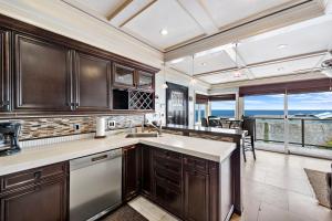 cocina con armarios de madera y vistas al océano en Villa Da Vinci at the Retreat at Laguna Beach, en Laguna Beach