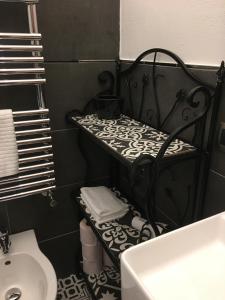 un baño blanco y negro con un estante junto a un lavabo en casa vacanza serena, en Palazzago