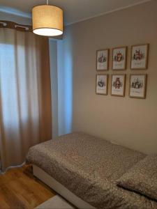 1 dormitorio con 1 cama y 4 cuadros en la pared en Przytulne mieszkanie w Olkuszu/ Cosy apartment in Olkusz, en Olkusz