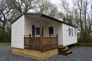 a tiny house with a porch and a deck at Camping du Creulet in Crouay